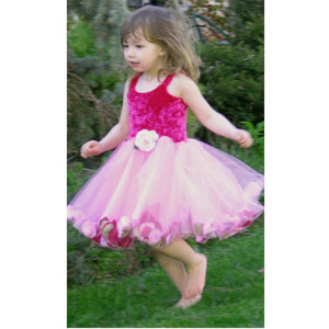 girl running through grass in pink fairy dress